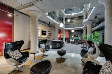 Minneapolis apartment for rent - A modern living room with black chairs and a red wall.