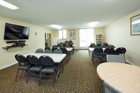 St. Thomas apartment for rent - Wellington Park Towers social room with tables and chair and tv in St. Thomas, ON