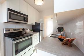 Toronto apartment for rent - A kitchen with a stove, microwave, and refrigerator.