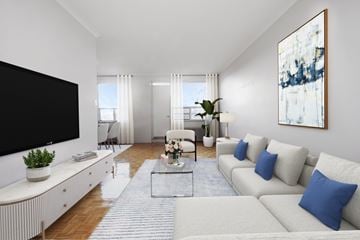 Toronto apartment for rent - A living room with a white couch, a black television, and a painting on the wall.