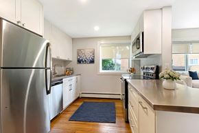 Brockville apartment for rent - A kitchen with a stainless steel refrigerator and white cabinets.