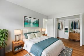 Brockville apartment for rent - A bedroom with a large bed and a painting on the wall.