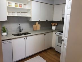 Toronto apartment for rent - A kitchen with white cabinets and a grey backsplash  at Angus House in Toronto