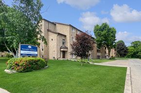 Brockville apartment for rent - Kensington Apartments in Brockville Ontario showing a blue and white community sign and building in the background