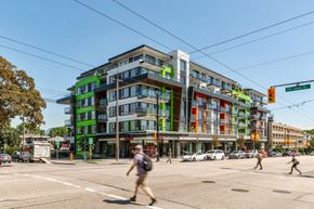Vancouver apartment for rent - A street view of a multi-story building with a green and orange facade at 388 Kaslo East Village Apartments.