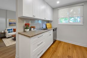 Brockville apartment for rent - A kitchen with white cabinets and a wooden floor.