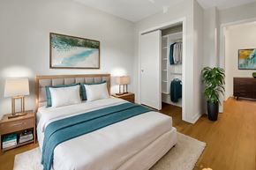 Brockville apartment for rent - A bedroom with a large bed and a painting on the wall.