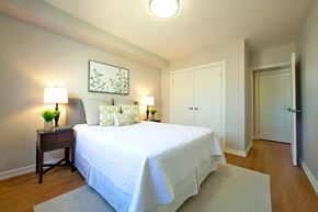 Niagara Falls apartment for rent - A bedroom with a bed, nightstand, and two lamps.