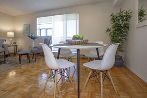 Cornwall apartment for rent - Dining room with white four-seater dining set and plant in a standard suite at Lorneville Apartments in Cornwall, ON
