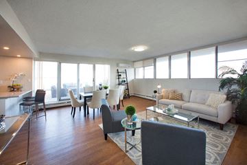 Hamilton apartment for rent - A modern living room with a white sofa and a glass coffee table.