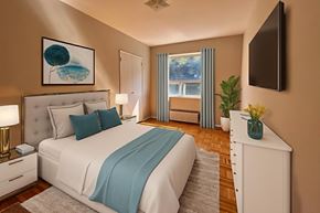 North York apartment for rent - A bedroom with a large bed and a television on the wall.
