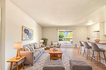 Belleville apartment for rent - A living room with a grey sofa, a wooden coffee table, and a painting on the wall.