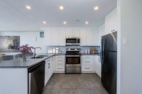 Bradford apartment for rent - U-shaped open concept kitchen at Park Place Apartments in Bradford with breakfast bar, stainless steel dishwasher, stove, over-the-range microwave and fridge