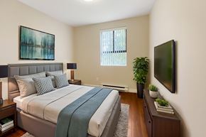 Kingston apartment for rent - A bedroom with a large bed and a flat screen TV mounted on the wall.