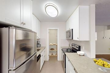 London apartment for rent - A kitchen with a refrigerator on the left and a microwave above the stove.