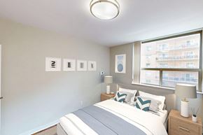 London apartment for rent - A bedroom with a large bed and a window in a renovated 2 bed 1.5 bath suite at Somerset Place in London, ON.