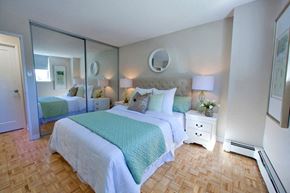 Barrie apartment for rent - Sunnidale Place Modern bedroom with white covers and light blue blankets and mirrored closet doors in Barrie, ON