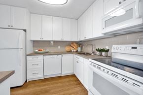 St. Thomas apartment for rent - Sunset Towers kitchen with white cabinetry, fridge, dishwasher, stove and over-the-range microwave in St. Thomas, ON