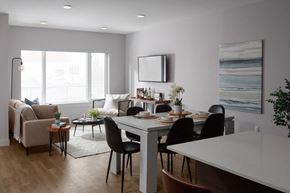 Kelowna apartment for rent - A modern dining room with a white table and black chairs at The Ambrosi in Kelowna, BC.