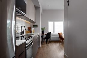 Kelowna apartment for rent - A modern kitchen with a dining table and chairs at The Ambrosi in Kelowna, BC.