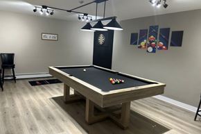 Niagara Falls apartment for rent - A pool table with a black felt cloth and a light hanging above it.