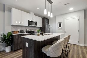 Waterloo apartment for rent - an open kitchen with an island and chairs at Vale Station Apartments in Waterloo ON