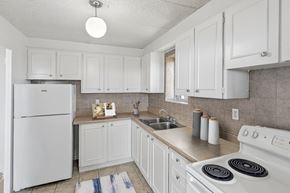 North York apartment for rent - Kitchen with fridge, stove, cabinetry and window at Village Tower Toronto ON