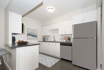 Aurora apartment for rent - A modern kitchen with white cabinets and a grey refrigerator.