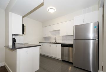 Aurora apartment for rent - A kitchen with a stainless steel refrigerator and white cabinets.