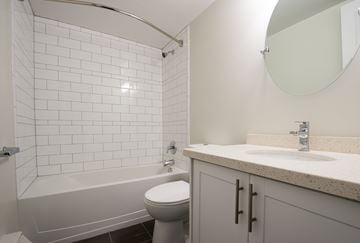 Aurora apartment for rent - A white bathroom with a toilet, sink, and bathtub.