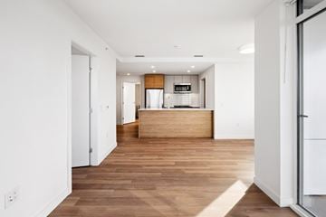 Vancouver apartment for rent - A modern kitchen with a wooden island and white walls.