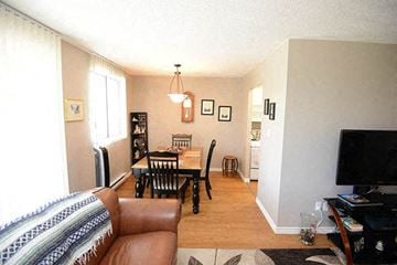 Amherstburg apartment for rent - A living room with a brown leather couch and a wooden coffee table.