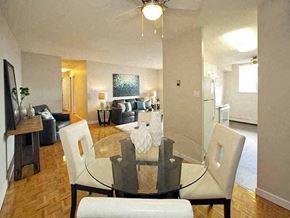 Barrie apartment for rent - Highpoint Barrie Dining room with glass table and four white chairs that has a view of the living room and balcony in Barrie, ON