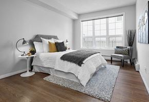 Edmonton apartment for rent - A bedroom with a large bed and a chair.
