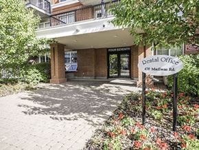 Edmonton apartment for rent - The entrance to the Four Seventy dental office is framed by a brick wall and a flower bed.