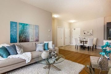 Calgary apartment for rent - A living room with a grey couch and a glass coffee table.