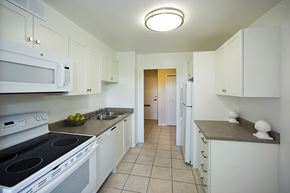 Toronto apartment for rent - Brookbanks kitchen with white cabinetry and full range stove and over-the-range microwave in Toronto, ON