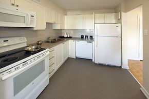 Toronto apartment for rent - Rockford Apartments kitchen with white cabinetry and full range stove and over-the-range microwave in Toronto, ON