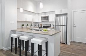 Nanaimo apartment for rent - A kitchen with white cabinets and a white fridge.