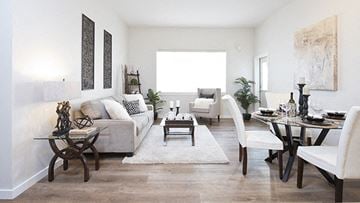 Nanaimo apartment for rent - A living room with a white couch, a coffee table, and a dining table with chairs.