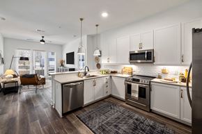 Wake Forest apartment for rent - A modern kitchen with white cabinets and stainless steel appliances.