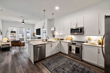 Wake Forest apartment for rent - A modern kitchen with white cabinets and stainless steel appliances.