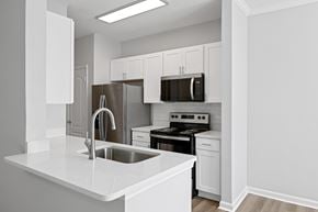 Mt. Pleasant apartment for rent - A kitchen with white cabinets and appliances.