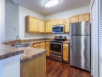 Orlando apartment for rent - a kitchen with stainless steel appliances and wooden cabinets