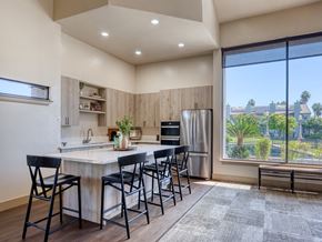 Fresno townhouse for rent - A kitchen with a table and chairs and a window overlooking a city.