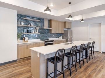 Logan apartment for rent - A kitchen with a white counter top and black bar stools.
