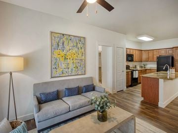 South Jordan townhouse for rent - A living room with a grey couch and a painting on the wall.