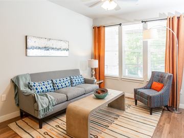South Jordan townhouse for rent - A living room with a grey couch, a blue chair, and a painting on the wall.