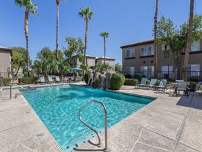 Surprise apartment for rent - A swimming pool surrounded by palm trees and lounge chairs.