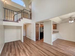 Fresno townhouse for rent - A spacious room with wooden flooring and a balcony with a railing.
